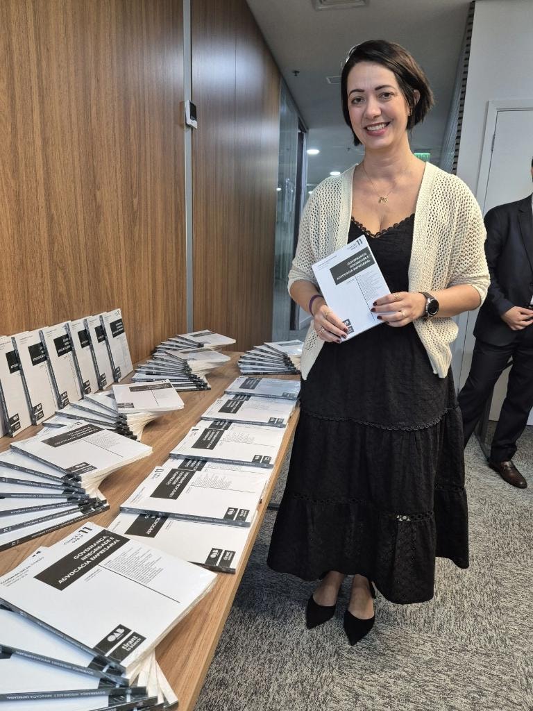 Daniella Fogaça ao lado de exemplares das obras jurídicas da OAB/SP